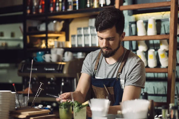 Mladý muž barman připravuje koktejl alkoholu — Stock fotografie