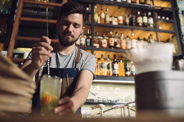 Mladý muž barman připravuje koktejl alkoholu — Stock fotografie