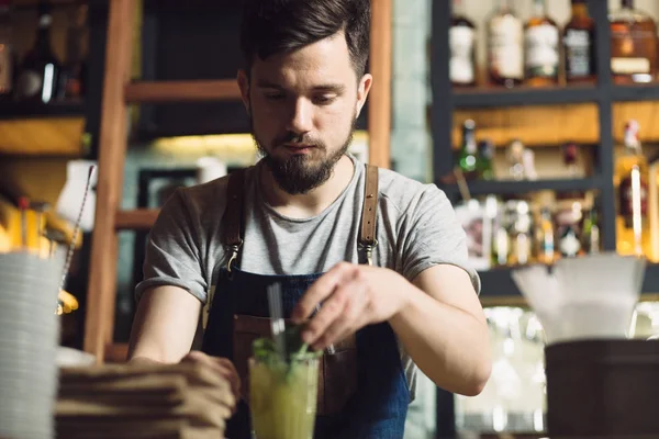 Mladý muž barman připravuje koktejl alkoholu — Stock fotografie