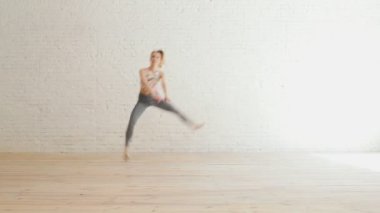 Kadın beyaz bir stüdyoda akrobatik bazı unsurlar yapma