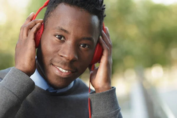Hombre afroamericano escucha música en la ciudad — Foto de Stock
