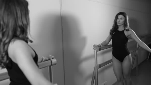 Mujer en traje de cuerpo haciendo ejercicio en la barra en la sala — Vídeos de Stock