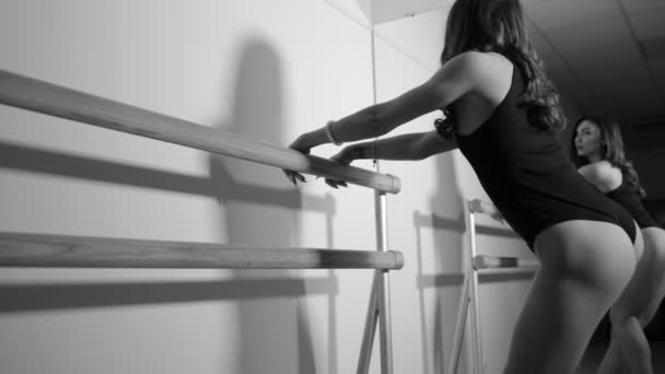 Woman in bodysuit making exercise at barre in hall — Stock Video