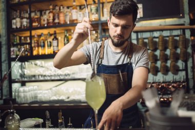 Genç erkek barmen bir alkol kokteyl hazırlama