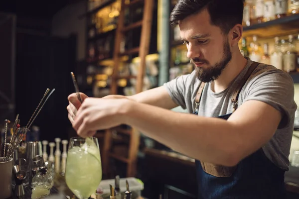 Mladý muž barman připravuje koktejl alkoholu — Stock fotografie