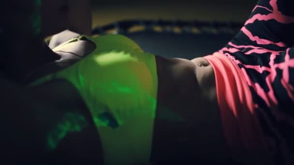Mooie sport vrouw pompen pers spier op trampoline in donkere sportschool — Stockvideo