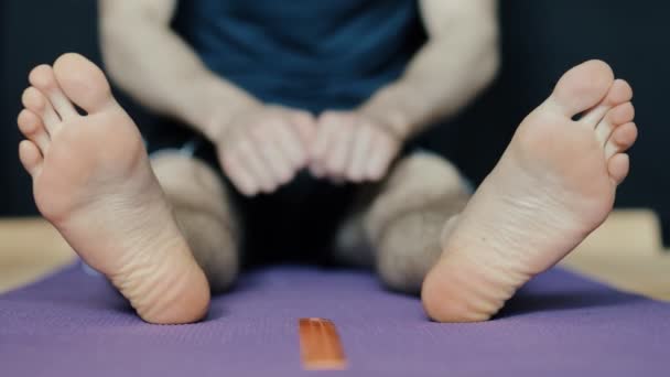 Mannen stretching benen på golvmatta — Stockvideo