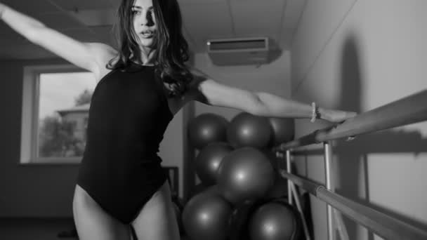 Woman in bodysuit making exercise at barre in hall — Stock Video