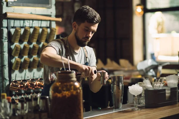 Mladý muž barman připravuje koktejl alkoholu — Stock fotografie