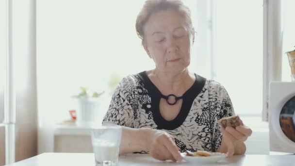 快乐的老年妇女吃午餐，喝牛奶 — 图库视频影像
