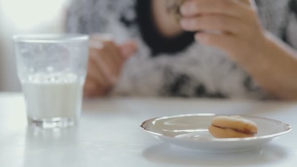 Primer plano de la mujer mayor comiendo galletas y bebiendo leche — Vídeos de Stock