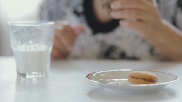 Primer plano de la mujer mayor comiendo galletas y bebiendo leche — Vídeo de stock