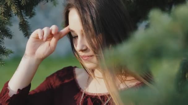 Nyugodt fiatal nő, egy park ül fej koszorú — Stock videók