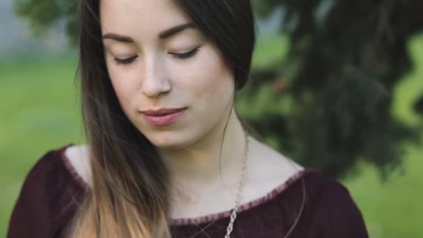 Mujer bonita abriendo los ojos sentado en un parque — Vídeos de Stock