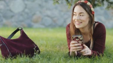 Bir çim üzerinde yalan ve smartphone kullanarak güzel kadın