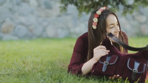 Hermosa mujer acostada en una hierba y divirtiéndose — Vídeo de stock