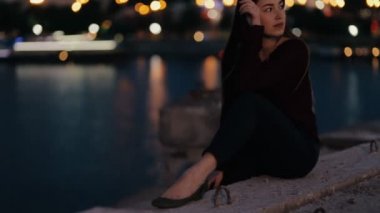 Akşamları bir köprü üzerinde oturan kadın güzel ve sakin ol
