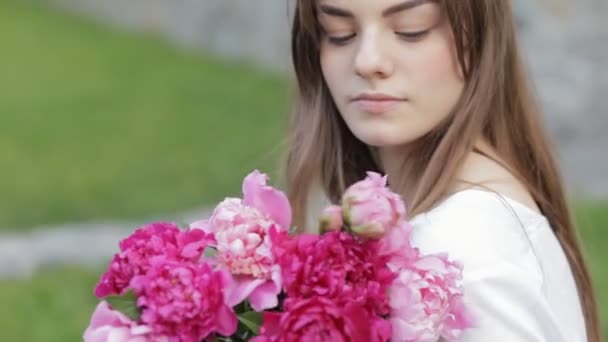 Vrouw maakt boeket van pioenrozen zitten in park — Stockvideo