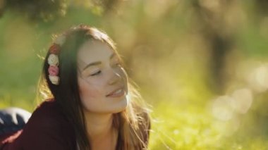 Bir çim üzerinde yalan ve kameraya bakarak güzel kadın