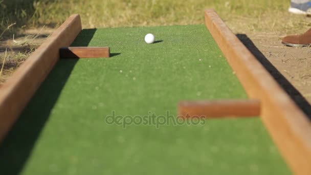 Poner pelota en el mini campo de golf — Vídeos de Stock