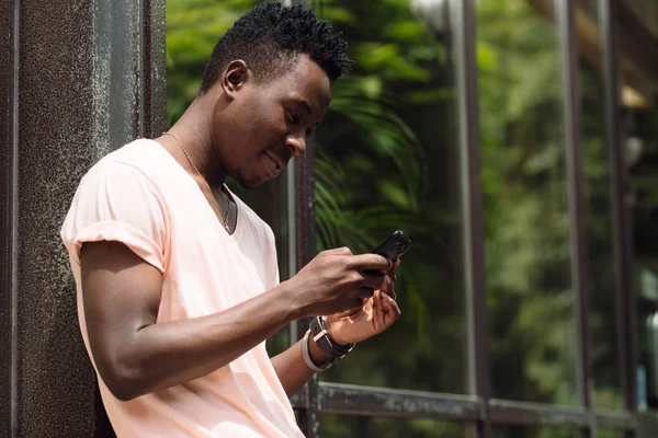 Αφρικανική αμερικανική άνθρωπος που χρησιμοποιούν κινητό στην πόλη το καλοκαίρι — Φωτογραφία Αρχείου