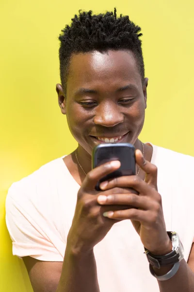 Αφρικανική αμερικανική άνθρωπος που χρησιμοποιούν κινητό σε κίτρινο φόντο — Φωτογραφία Αρχείου