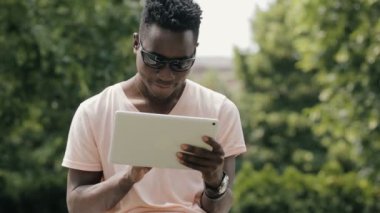 Siyah adam parkta beyaz tablet Pc kullanma