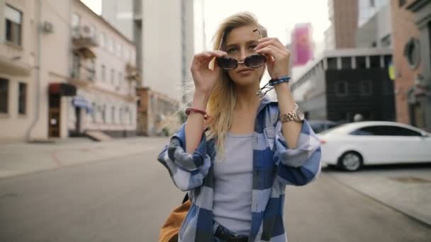 Fashionable woman walking in street wearing sunglasses - slow motion — Stock Video