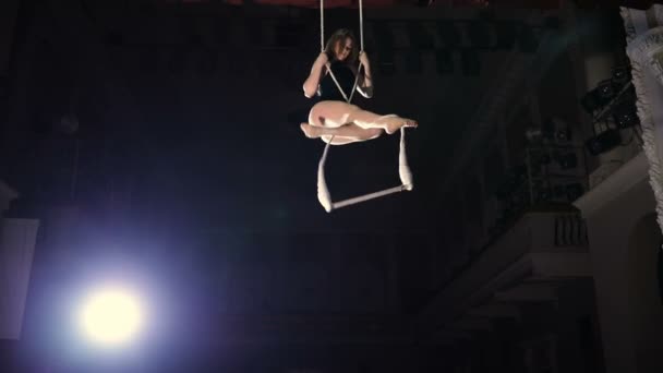 Artista de circo feminino em uma barra de trapézio em câmara lenta — Vídeo de Stock