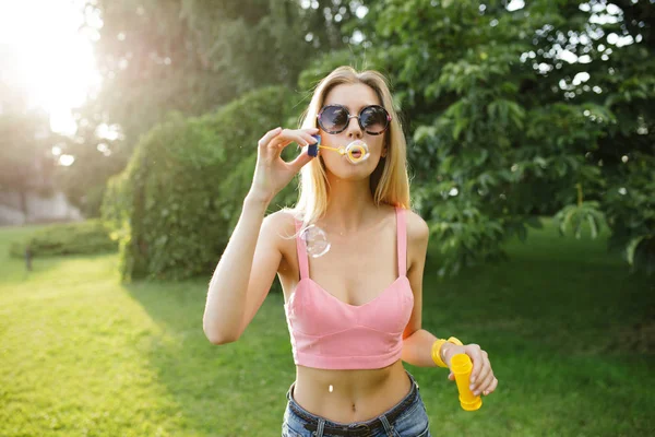 Mulher bonita soprando bolhas no parque de verão — Fotografia de Stock