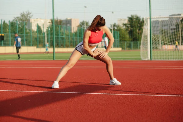 Žena, mladý roztomilý fitness. Atraktivní sportovní dívka táhne a zahřívání před tréninkem cvičení stadionu, koncept zdravého životního stylu. — Stock fotografie