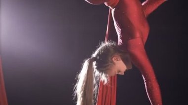 Üzerinde kırmızı ipek bir sirk aşamasında performans kadın hava jimnastikçi. Heyecan verici akrobatik gösterisi.