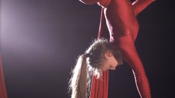 Kvinnliga antenn gymnasten utför på ett rött siden i en Cirkus scen. Spännande akrobatisk show. — Stockvideo