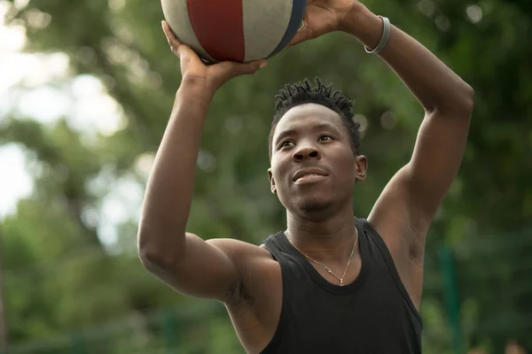 Portret van Afro-Amerikaanse man Gooi bal op basketbalveld — Stockfoto