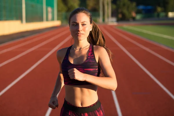 Professional sportswoman athlete sprinter running on stadium track in evening. Healthy lifestyle concept. Forward to the victory. — Stock Photo, Image