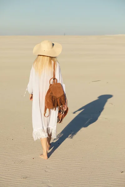 Matka yksin. Nainen kävelee pois hiekalla aavikolla . — kuvapankkivalokuva