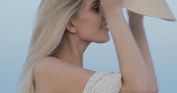 Schönes Porträt einer Frau mit Hut und Badeanzug, die draußen vor der Kamera posiert — Stockvideo