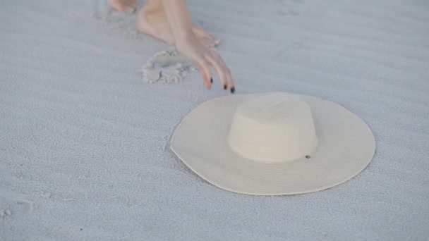 Cropped of unrecognizable woman take hat from sand on beach — Stock Video