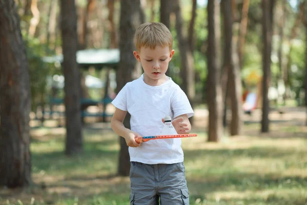 Liten gutt spiller badminton i en furuskog, aktiv hvile i naturen – stockfoto