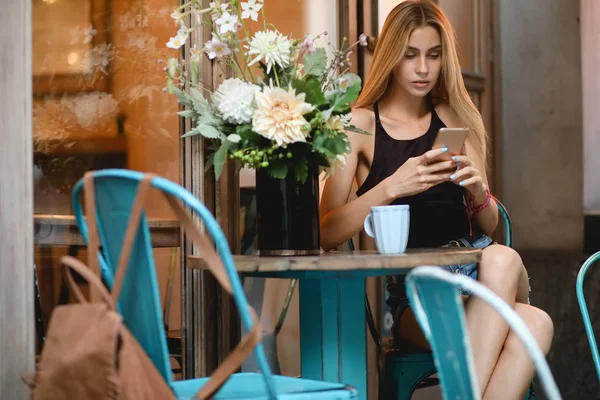 Internet-riippuvuus. Nainen ulkona kahvilassa älypuhelimella . — kuvapankkivalokuva