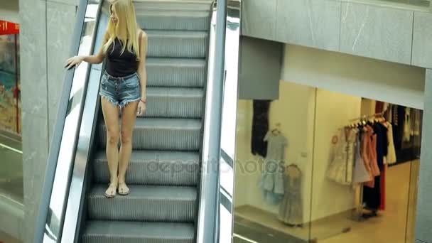 Frau in Einkaufszentrum fährt Rolltreppe, Transporttreppe, Rolltreppe — Stockvideo