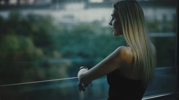 Mujer mirando a los árboles de verano en la ventana, vista trasera — Vídeos de Stock