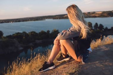 Uzun yürüyüşe çıkan kimse kız. Yalnız yolculuk. Genç kadın ile macera seyahat. O doğa üzerinde oturan ve taş ocağına görünüyor.