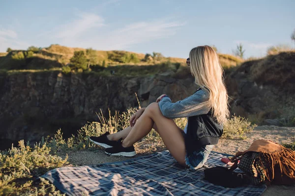 Tramp dívka. Cestu sám. Mladá žena cestovat dobrodružství. Ona sedí na přírodu a vypadá na lomu. — Stock fotografie