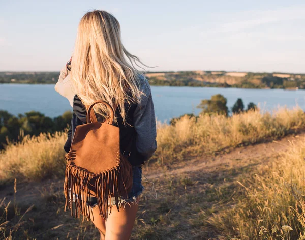 Chica excursionista. Viaje solo. Viaja una joven. Ella de pie en la naturaleza y mira al río. Vista trasera . —  Fotos de Stock