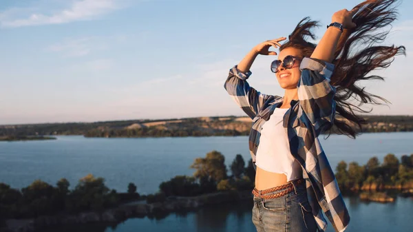 Krásná mladá cestovní žena s létáním vlasy. Turistické dívka se těší letní dovolenou při západu slunce. — Stock fotografie