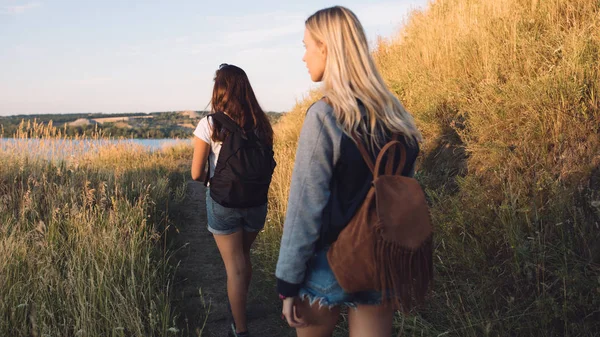 Best friends hiking together. Two young women travel with adventure. Girls walking in nature on summer vacation.