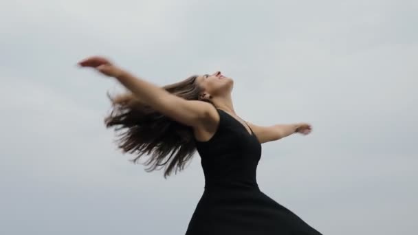 Frihet, lycklig kvinna virvlar runt. Hon rotera på grumlig lynnig himmel bakgrund. Ler utomhus i naturen, har kul. — Stockvideo