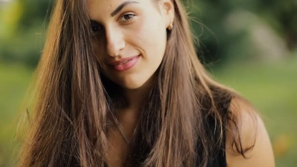 Retrato de cerca de una mujer bastante modesta con cabello hermoso en un parque en el día de verano — Vídeos de Stock