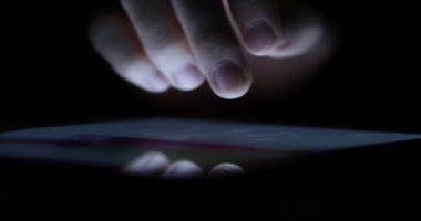Tatlı bir erkek el dijital tablet geç saatlere kadar üzerinde bir Web sayfası aracılığıyla kaydırma